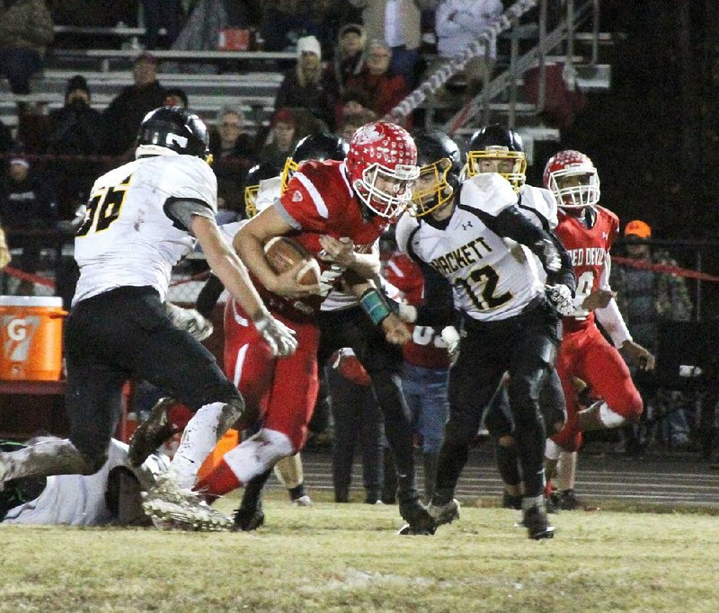 Mountain Pine’s Collin Smith (center) and the Red Devils will be playing Des Arc in their second-round playoff game Friday night at Fountain Lake High School because their home field is in poor condition, thanks to an excess amount of rain so far in November. 