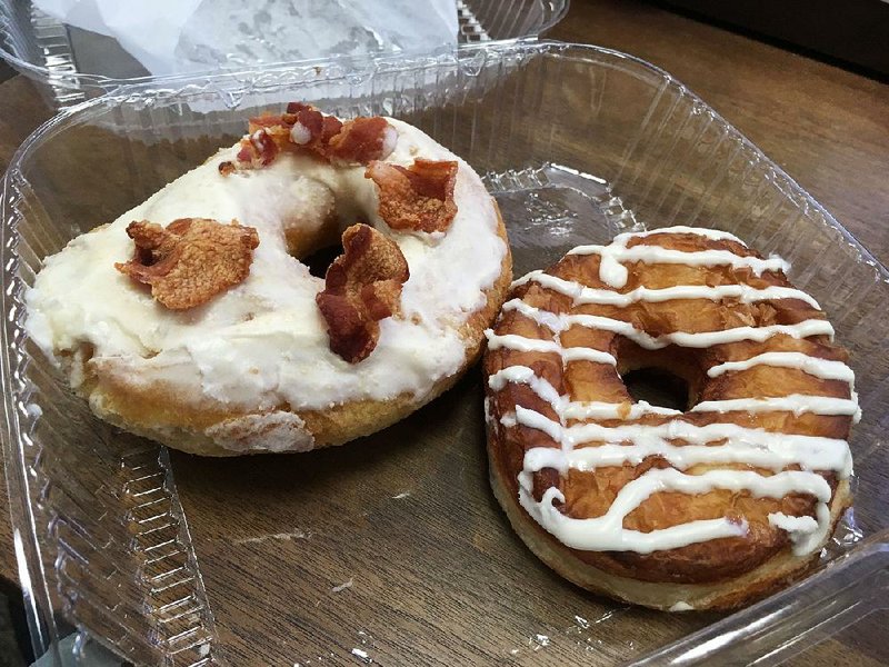 Specialties at Donuts & Deli include a maple bacon doughnut (left) and iced CroNut. 