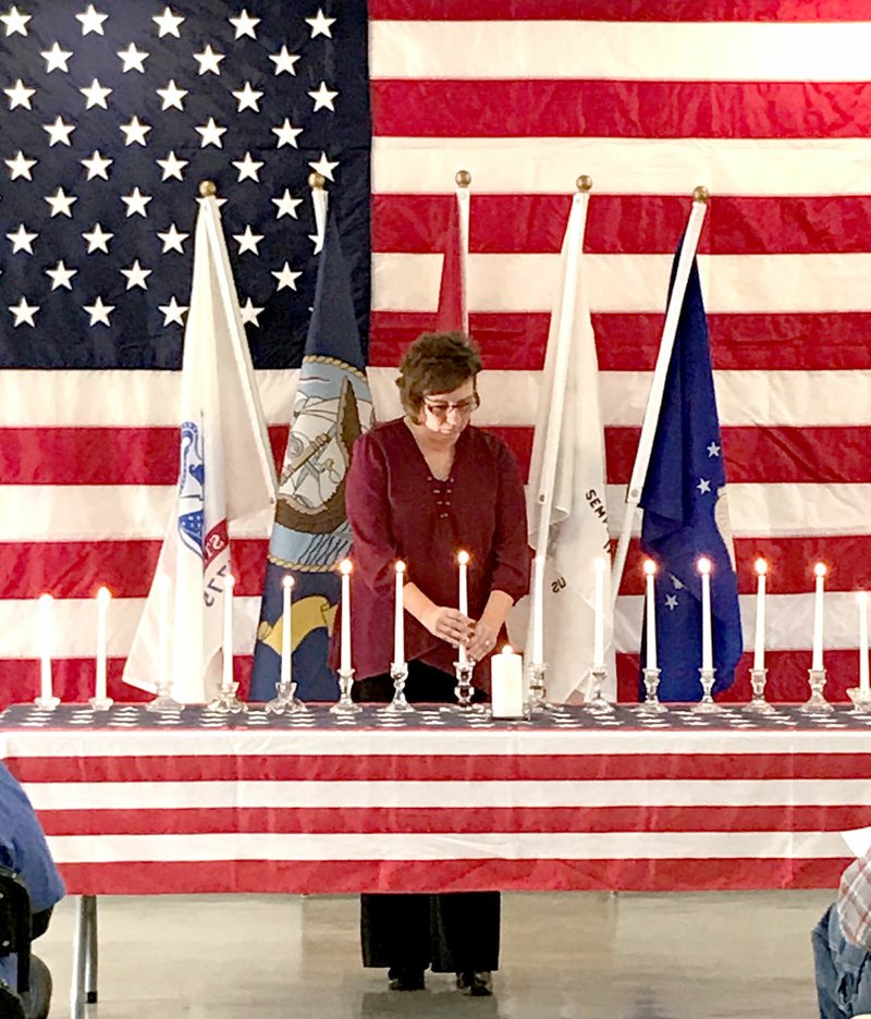 Courtesy photo Veteran Kim Bell lights candles during a special ceremony honoring all veterans on Sunday afternoon. The program, which was held at the Pineville Community Center, honored 17 McDonald County servicemen who lost their lives in World War I. The McDonald County Historical Society hosted the ceremony to highlight and show respect for all veterans who have served.