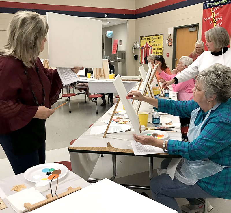 Courtesy photo Retired art teacher Charlene Bergen leads a fall painting class as a fundraiser for MC4Kids in Noel. The $500 raised will help secure additional food staples for local families over the holiday season. Food donations are still be accepted at any local school.