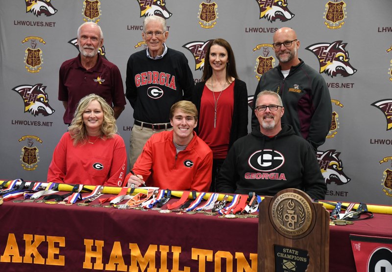The Sentinel-Record/Grace Brown VAULTING TO THE SEC: Lake Hamilton senior track and field athlete Haze Farmer, front center, signed a national letter of intent Wednesday at the school to join Georgia's program in 2019. He was joined, in front, by his mother, Mecca Hill, left, and his father, David Farmer, and back, from left, coach Karl Koonce, grandfather George Hill, stepmother Mindy Farmer and coach Morry Sanders.
