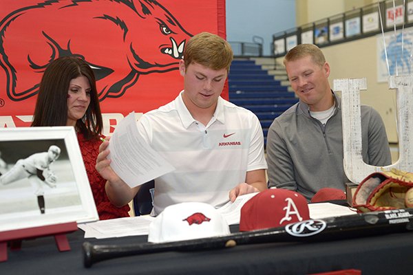 Har-Ber baseball standout Blake Adams (center) signs a National Letter of Intent Wednesday, Nov. 14, 2018, to play baseball for Arkansas while seated alongside his mother, Alicia, and father, Aaron, during a signing ceremony inside Wildcat Arena in Springdale.