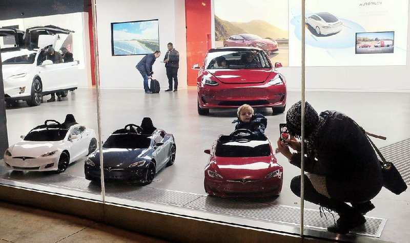 A child climbs into a battery operated ride-on Tesla car, at a showroom in Chicago last weekend. U.S. retail sales rose in October by 0.8 percent, the Commerce Department said Thursday. 