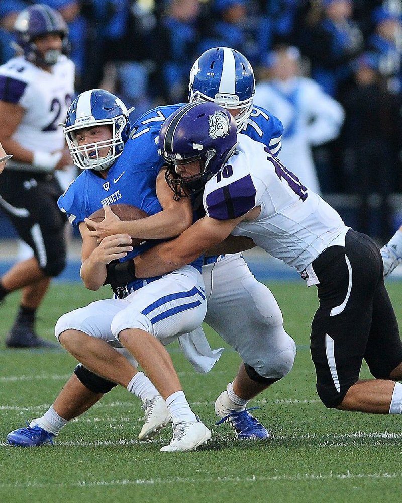 Bryant quarterback Ren Hefley (left) is sacked by Fayetteville linebacker Quade Mosier during the Hornets’ 36-35 loss to the Bull- dogs on Sept. 14. Coach Buck James said it will be a game-time decision between Hefley and junior Austin Ledbetter as the starter for today’s game in Bryant.