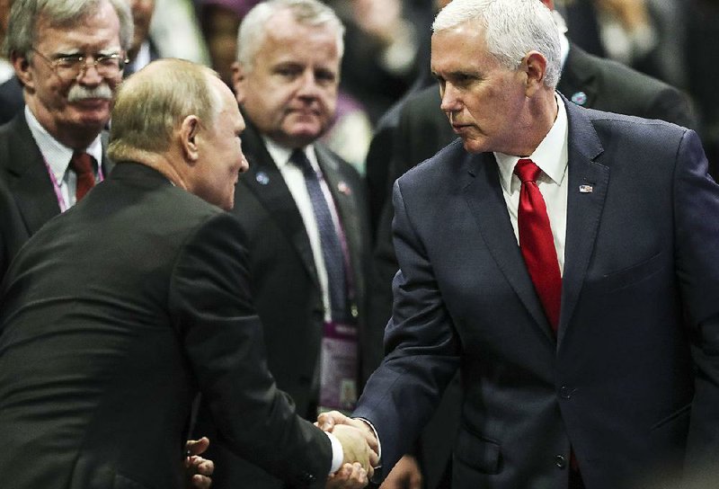 Russian President Vladimir Putin and Vice President Mike Pence share a moment Thursday at the Association of Southeast Asian Nations summit in Singapore. At left is White House national security adviser John Bolton. 