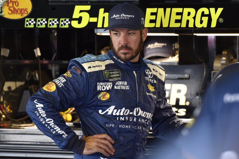 FILE - In this July 28, 2018, file photo, Martin Truex Jr. looks over his car in the garage during practice for the NASCAR Cup Series auto race in Long Pond, Pa. Truex is one NASCAR's four title contenders for Sunday's championship race. The others are Kevin Harvick, Kyle Busch and Joey Logano. (AP Photo/Derik Hamilton, File)