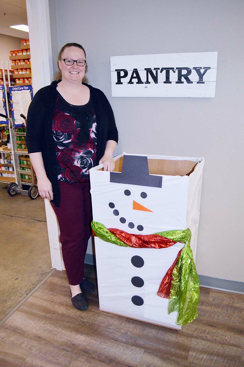 Melissa Allen, programs director for the Community Action Program for Central Arkansas, stands with a snowman box in Conway decorated by volunteers to collect donations for the food pantry that serves Faulkner County. A Deck the Box contest is being held in Faulkner, Cleburne and White counties to stock depleted food pantries. People can vote for their favorite boxes on the CAPCA Facebook page.