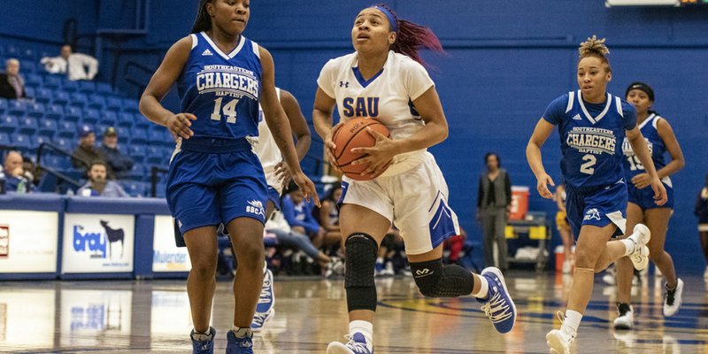 SAU freshman Ariana Guinn drives past a couple of Southeastern Baptist Lady Chargers during the Lady Muleriders’ 40-point victory Tuesday night. The will head to Rolla, MO, Saturday for a 1 p.m. game against Missouri S&T.