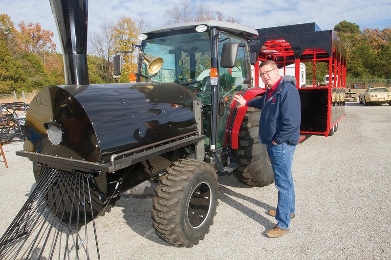 Johnathan Abbott, landscape supervisor for the city of Batesville, stands next to a tractor that has been converted to look like a train engine that will pull two trailers, which look like rail cars, for the White River Wonderland at Riverside Park. The annual Christmas lights display starts Wednesday.