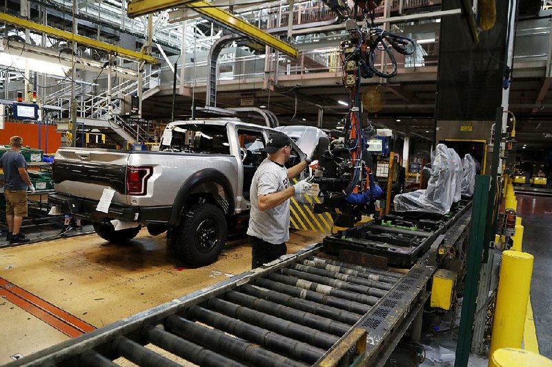 A worker installs seats in a F-150 pickup in September at the Ford Rouge assembly plant in Dearborn, Mich. Factory output rose in October despite a drop in auto production. 