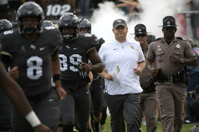 Central Florida Coach Josh Heupel (center) leads the No. 11 Knights in a game against No. 24 Cincinnati for first place in the American Athletic Conference’s East Division. 