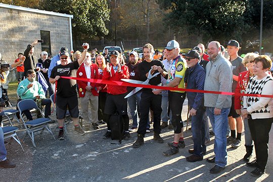 The Sentinel-Record/Richard Rasmussen TRAIL OPEN: Mayor Pat McCabe and The Walton Foundation Program Director Gary Vernon officially opened the Northwoods Trail system by cutting a ribbon at a ceremony Friday.