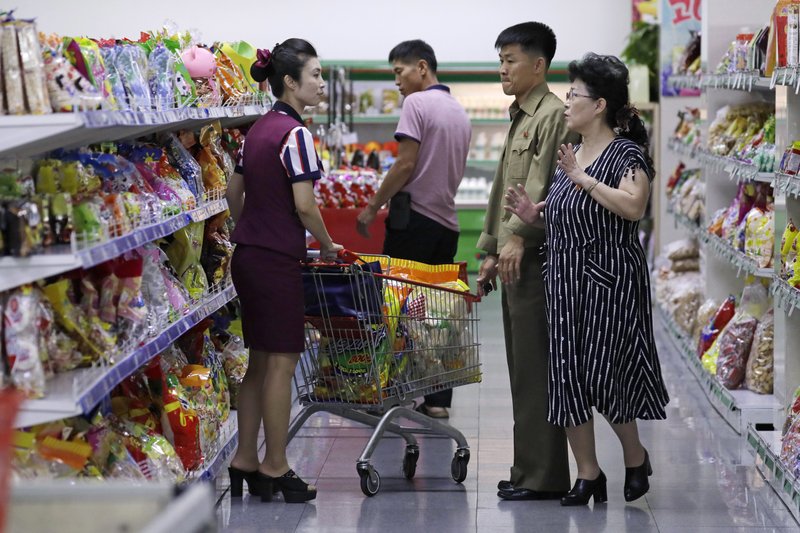 FILE - In this Sept. 12, 2018, file photo, North Korean customers get assistance at a supermarket in Pyongyang, North Korea. One of the biggest mysteries among North Korea economy watchers is how the country has managed to maintain stable exchange rates despite intense sanctions, political tensions and a swelling trade imbalance. The North claims it simply shows how strong the economy really is. But outside experts say it could reflect anything from tight loan policies and government restrictions on speculative dealing to a massive sell-off of state assets. (AP Photo/Kin Cheung, File)