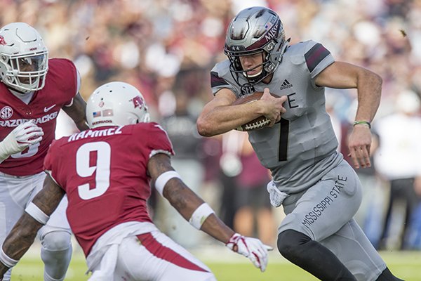 Mississippi State quarterback Nick Fitzgerald carries the ball while Arkansas defenders Santos Ramirez (9) and De'Jon Harris (8) try to tackle him during a game Saturday, Nov. 17, 2018, in Starkville, Miss.