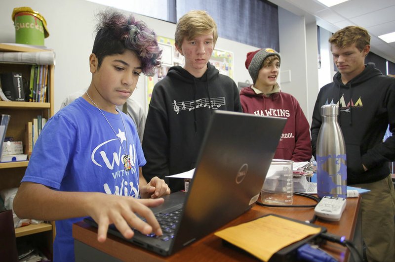 NWA Democrat-Gazette/DAVID GOTTSCHALK Yazan Aldhamen, a freshman at Fayetteville High School, enters results Nov. 9 from a radio active isotopes simulation group project to experience the metric dating of fossils in Cameron Simpkin's Pre AP biology class at Fayetteville High School. The school is one of 103 schools nationwide participating this year in a pilot of the College Board's pre-Advanced Placement program.