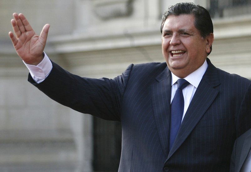 FILE - In this June 17, 2011 file photo, Peru's outgoing President Alan Garcia waves to the press during a meeting with Peru's President-elect Ollanta Humala at the government palace in Lima, Peru. Peru's government said in a Nov. 18, 2018 statement that the former president is seeking asylum in Uruguay days after a prosecutor sought to retain his passport as part of a corruption probe. (AP Photo/Marcelo Luna, File)