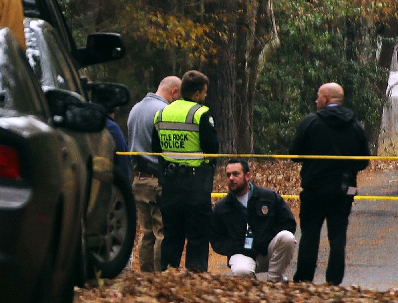 Little Rock Police detectives investigate a homicide on Loretto Lane on Sunday morning in Little Rock. It was the city’s fifth homicide since Friday. 
