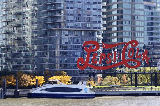 In this Nov. 7, 2018, photo, a water taxi approaches the Long Island City waterfront and new high-rise luxury apartment buildings, passing the landmarked PepsiCola sign in Gantry Plaza State Park in the Queens borough of New York. On Tuesday, Nov. 13, Amazon said it will split its second headquarters between Long Island City in New York and Crystal City in northern Virginia. (AP Photo/Mark Lennihan)