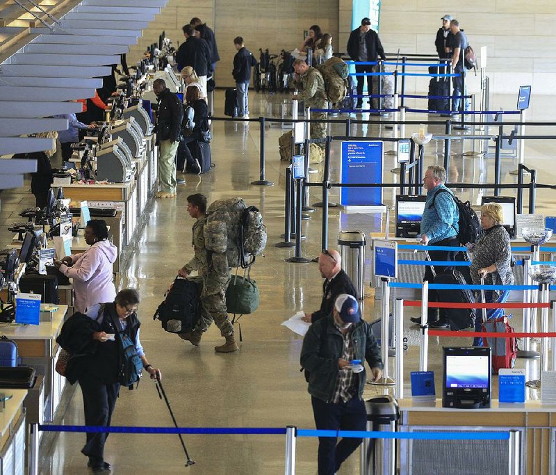 Travelers check in for flights Friday at Bill and Hillary Clinton National Airport/Adams Field as Thanks- giving holiday travel ramps up. 