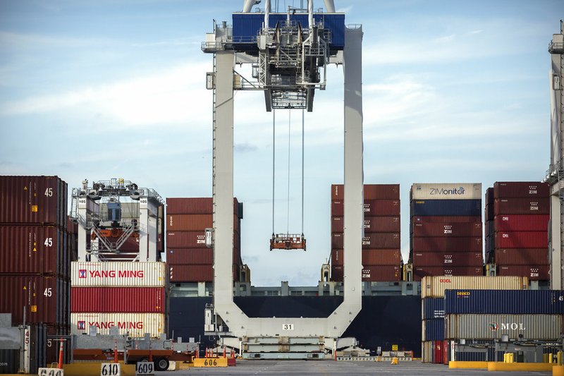 FILE - In this Thursday, July 5, 2018, photo, a ship to shore crane prepares to load a 40-foot shipping container onto a container ship at the Port of Savannah in Savannah, Ga. After galloping along for the past two years, the global economy is showing signs of weakening, with the United States, China and Europe all facing the rising threat of a slowdown. Few economists foresee an outright global recession within the next year. But the synchronized growth that powered most major economies since 2017 appears to be fading. (AP Photo/Stephen B. Morton, File)