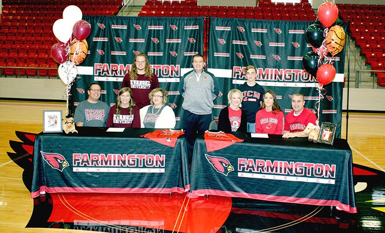 MARK HUMPHREY ENTERPRISE-LEADER Farmington senior Alexis Roach seated with her family (left) and teammate Madisyn Pense seated with her family (right) signed national letters of intent to play women's college basketball next year. Roach signed with Evangel University, of Springfield, Mo.; and Pense signed with Central Missouri University. Farmington girls basketball coach Brad Johnson (center) introduced the girls to students and fans celebrating the event at Cardinal Arena Wednesday, Nov. 14, 2018.