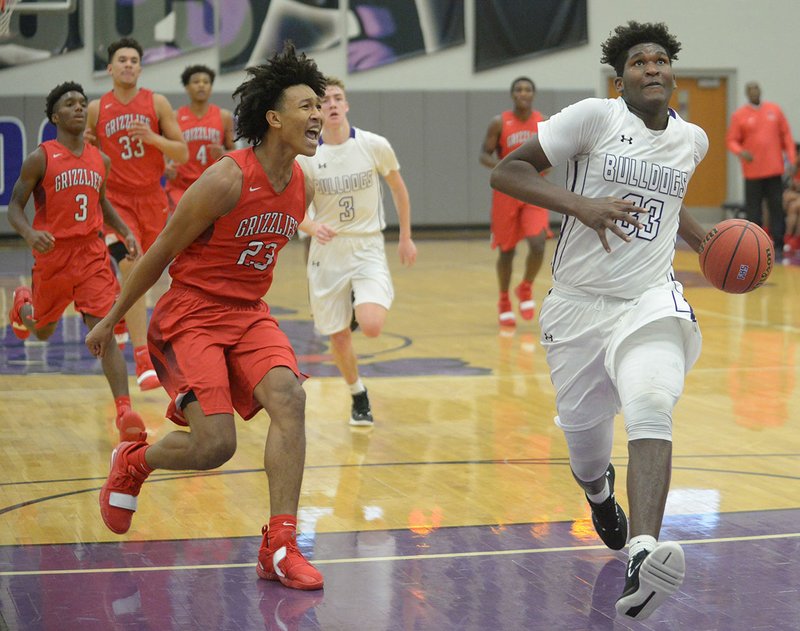 NWA Democrat-Gazette/ANDY SHUPE Fayetteville forward Tamaury Releford (right) drives through the lane past Fort Smith Northside forward Jaylin Williams (23) Tuesday, Nov. 20, 2018, during the second half of play in Bulldog Arena. Visit nwadg.com/photos to see more photographs from the game.