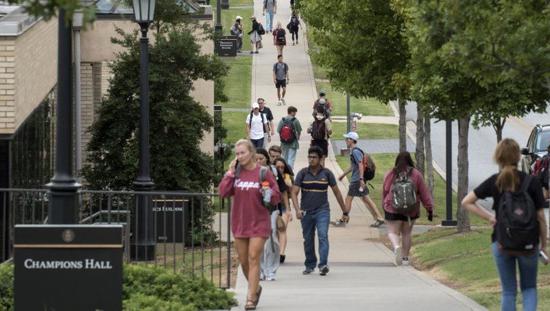 In this file photo University of Arkansas students make their way to classes on Dickson Street in Fayetteville.