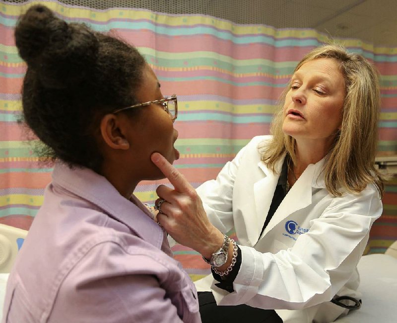 Dr. Stacie Jones checks over 17-year-old Carre’ Sadler, who suffers from a peanut allergy, during an examination at Arkansas Children’s Hospital in Little Rock. Special to the Democrat-Gazette