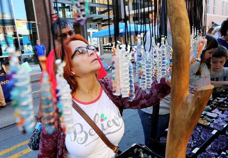 Fanny Salgado examines crystals on display at last year’s Think Big Shop Small event in Little Rock’s River Market District. 