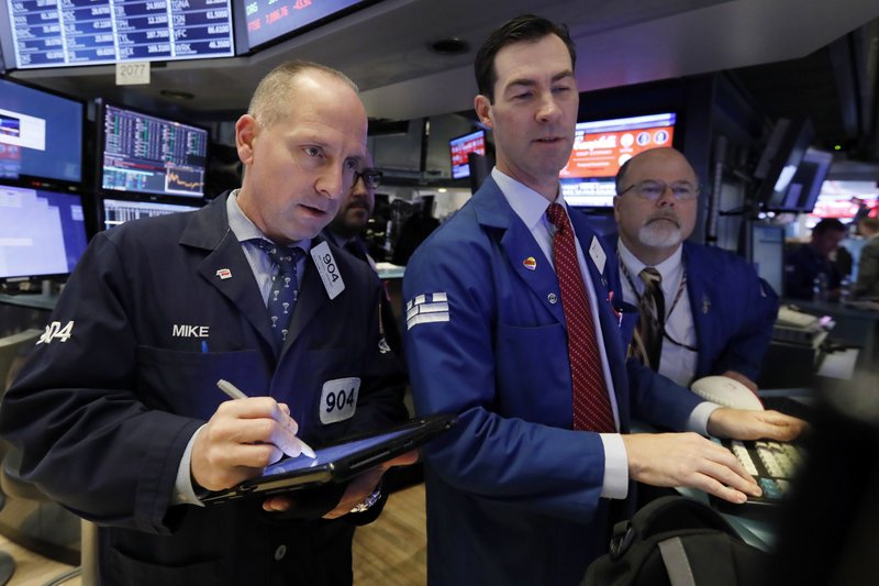 In this Friday, Nov. 9, 2018, file photo trader Michael Urkonis. left, works with specialists John McNierney, center, and Douglas Johnson on the floor of the New York Stock Exchange.  (AP Photo/Richard Drew, File)