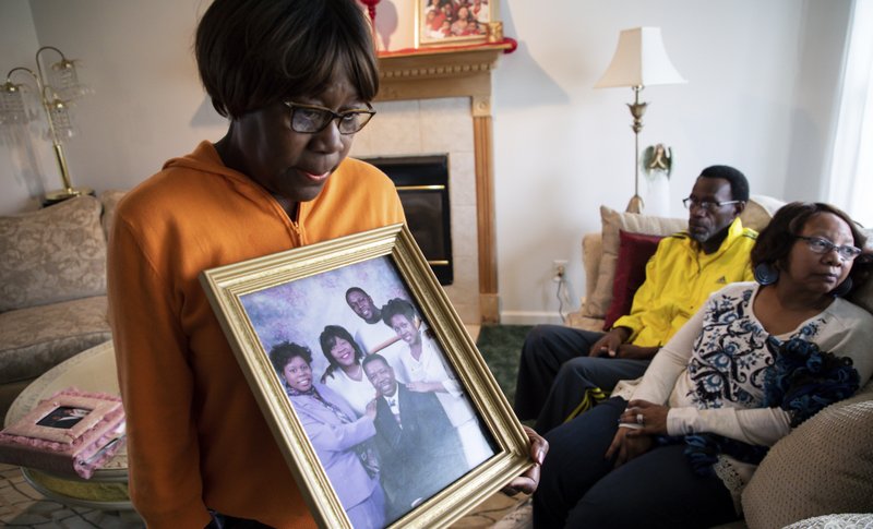 Glenda O'Neal, mother of of Dr. Tamara O'Neal, shows a photo of her family at their home in LaPorte, Ind., Tuesday, Nov. 20, 2018. Dr. Tamara was one of the three people fatally shot Monday at Mercy Hospital, a Chicago hospital. (Zbigniew Bzdak/Chicago Tribune via AP)