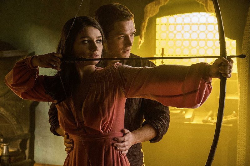 Robin of Loxley (Taron Egerton) instructs Marian (Eve Hewson) in the art of bow-drawing in Otto Bathurst’s Robin Hood, a politically freighted updating of the classic story.