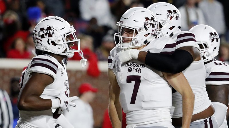 Mississippi State quarterback Nick Fitzgerald (7) is congratulated by teammates following an 8-yard touchdown run against Mississippi during the first half of an NCAA college football game in Oxford, Miss., Thursday, Nov. 22, 2018. (AP Photo/Rogelio V. Solis)
