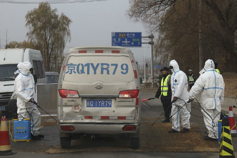 Workers disinfect vehicles Friday near Beijing after cases of African swine fever were reported in the city. The disease has killed 1 million pigs since it was detected in August. 