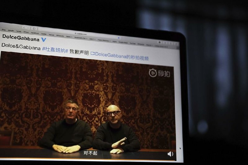 Dolce & Gabbana founders Domenico Dolce (left) and Stefano Gabbana, shown on a computer screen in Beijing, apologize in a video on Chinese social media, saying “sorry” in Mandarin after controversial video ads and insulting remarks attributed to Gabbana surfaced on Instagram. 