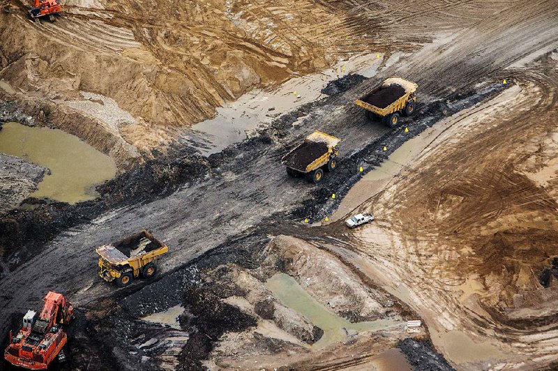 Heavy haulers work at the Suncor Energy Inc. Millennium mine in this aerial photo taken in September over the Athabasca oil sand in Alberta, Canada. 