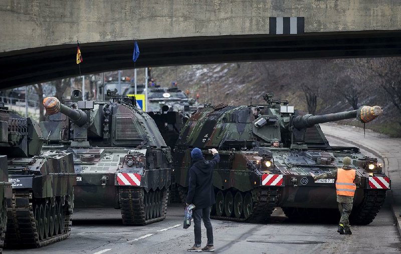 Armored vehicles on Friday get ready to rehearse for today’s parade in Vilnius, Lithuania, to mark the 100th anniversary of the restoration of the Lithuanian military after World War I. 