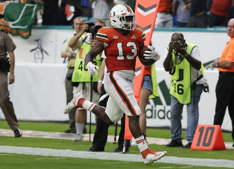 Miami running back DeeJay Dallas (13) ran a punt back 65 yards for a touchdown and ran 3 yards for another touchdown in the Hurricanes’ 24-3 victory over Pittsburgh on Saturday.