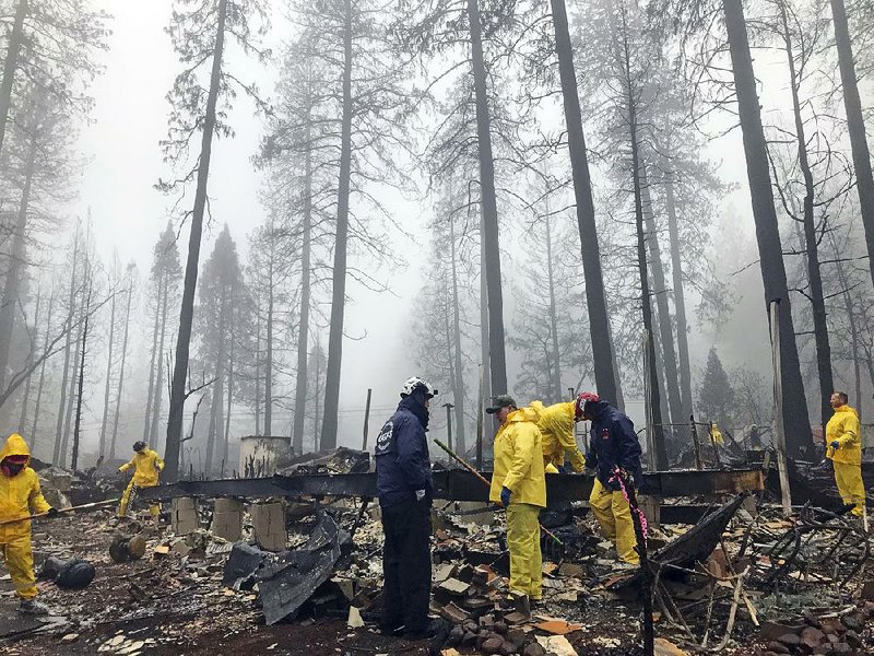 Volunteers at a mobile home park in Paradise, Calif., resume their search for the remains of wildfire victims Friday after a downpour caused a brief delay. 
