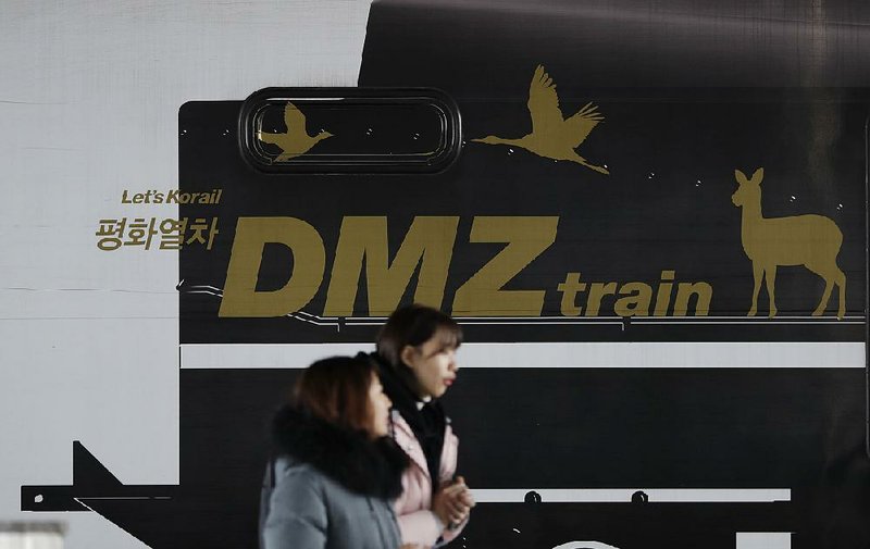 People walk past the DMZ Train on Saturday at Imjingang Station in Paju, South Korea. The train carries tourists between Seoul and the Demilitarized Zone that separates North and South Korea. 