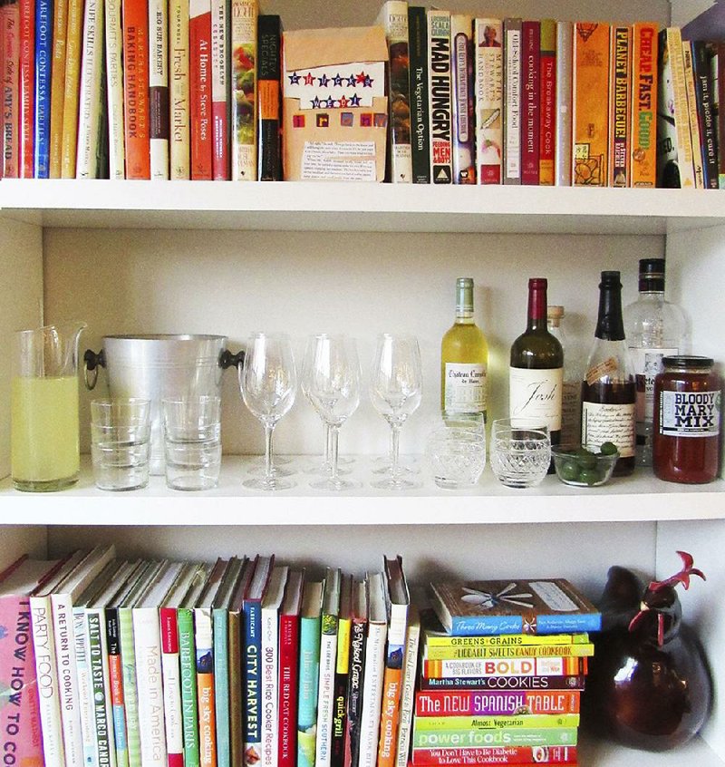 This November 2015 photo provided by Katie Workman shows a temporary bar for a party being set up in a bookcase in New York. Making the most of different areas of your home is very helpful when you have a big group over. 