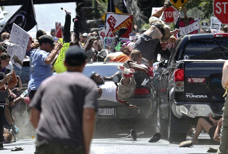  In this Aug. 12, 2017, file photo, people fly into the air as a vehicle is driven into a group of protesters demonstrating against a white nationalist rally in Charlottesville, Va. James Alex Fields Jr., the man accused of driving into the crowd demonstrating against a white nationalist protest, killing one person and injuring many more, heads to court Monday, Nov. 26, 2018. (Ryan M. Kelly/The Daily Progress via AP, File)