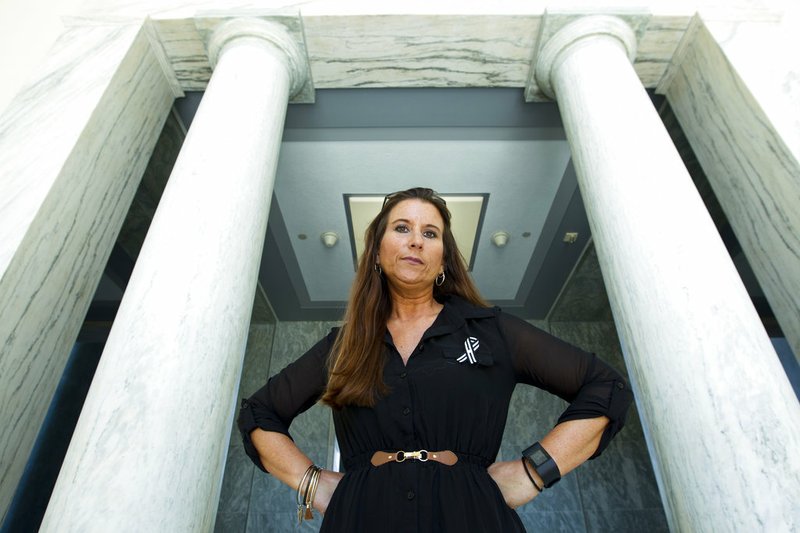 Jamee Cook poses for a photo at Rayburn House Office Building after meeting with congressional leaders on Capitol Hill, Thursday, Sept. 6, 2018, in Washington. Cook had breast implants that ruptured and which she believes caused her medical problems. She now is lobbying the FDA and congressional leaders to do a better job of tracking and regulating medical devices. (AP Photo/Jose Luis Magana)
