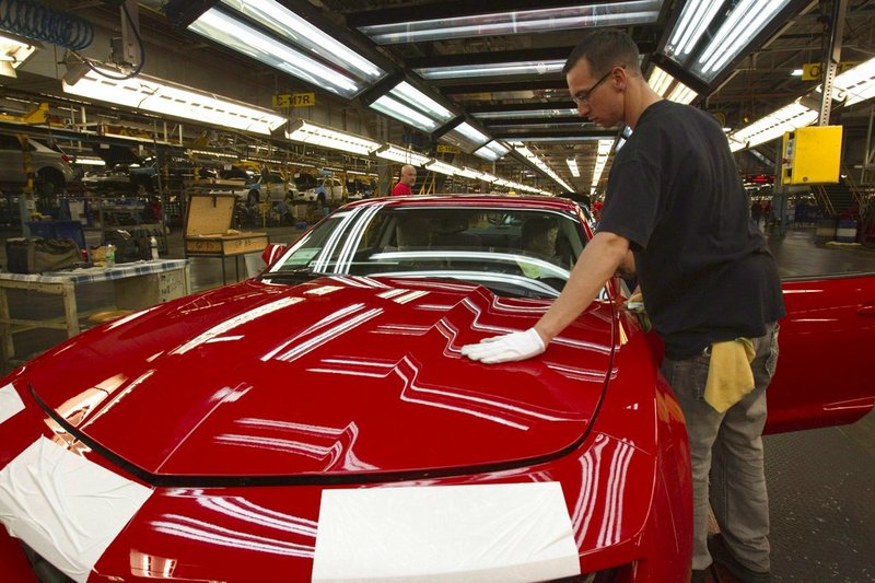 FILE - In this June 10, 2011, file photo, a worker checks the paint on a Camaro at the GM factory in Oshawa, Ontario. General Motors is closing a Canadian plant at the cost of about 2,500 jobs, but that is apparently just a piece of a much broader, company-wide restructuring that will be announced as early as Monday, Nov. 26, 2018. (Frank Gunn/The Canadian Press via AP, File)

