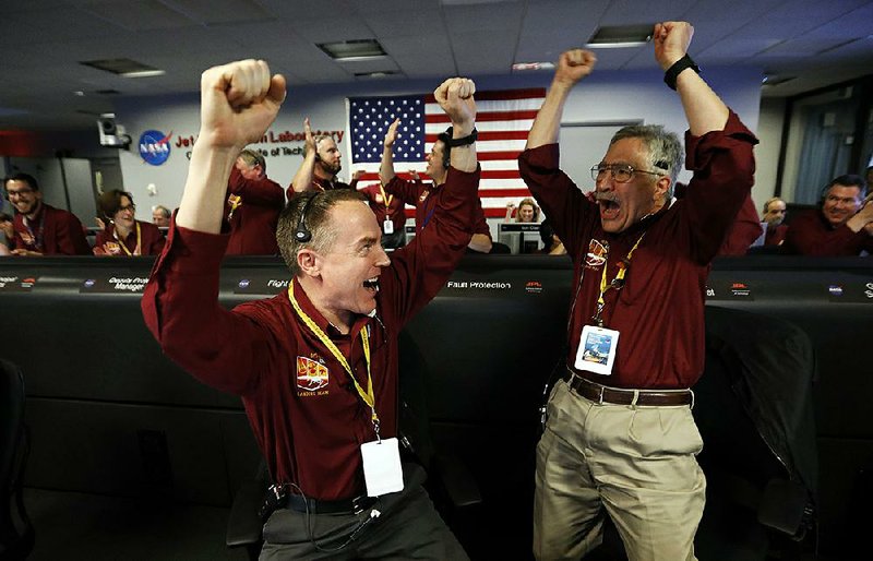 Engineers Kris Bruvold (left) and Sandy Krasner celebrate Monday at NASA’s Jet Propulsion Lab- oratory after the InSight lander touched down on the surface of Mars.