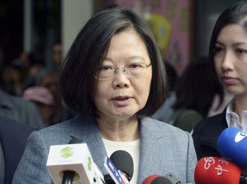 FILE - In this Nov. 24, 2018, file photo, Taiwanese President Tsai Ing-wen, center, speaks to journalists after a vote in local elections in New Taipei City, Taiwan. A strong showing by Taiwain's opposition Nationalist Party in this weekend's local elections presents a major challenge to independence-leaning President Tsai as she grapples with growing economic, political and military pressure from rival China. (Kyodo News via AP, File)