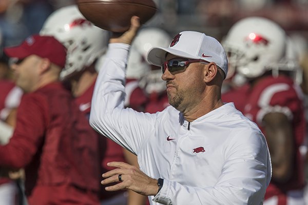 Arkansas running backs coach Jeff Traylor throws a football during warmups prior to the Razorbacks' game against Mississippi State on Saturday, Nov. 17, 2018, in Starkville, Miss. 
