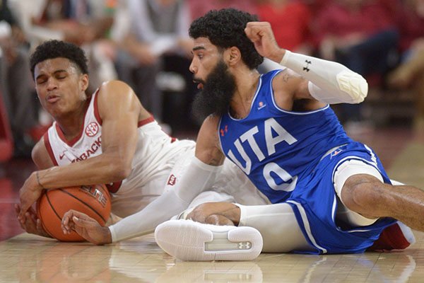 Arkansas guard Jalen Harris (left) and Texas-Arlington guard Brian Warren vie for a loose ball Friday, Nov. 23, 2018, during the first half of play in Bud Walton Arena in Fayetteville.
