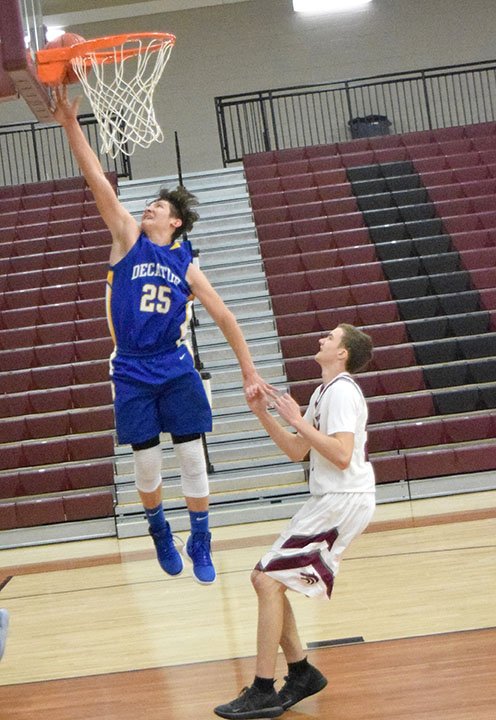 Westside Eagle Observer/MIKE ECKELS Kevin Garcia (Decatur 25) nearly dunks the ball during the Decatur-Lincoln Varsity basketball contest in Lincoln Nov. 19. Garcia got the ball to drop into the basket for two points for the Decatur Bulldogs.