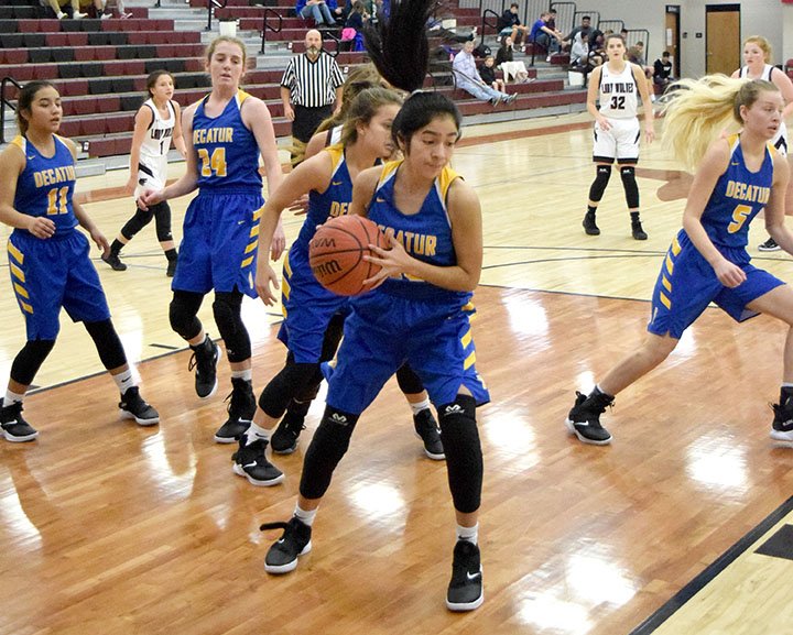 Westside Eagle Observer/MIKE ECKELS Stephanie Sandoval pulls down a rebound as her teammates began the transition from defense to offense during the first round of the Turkey Shoot Tournament action between the Decatur Lady Bulldogs and the Lincoln Lady Wolves in Lincoln Nov. 19. The five members of the Lady Bulldogs include Kaylee Morales (left), Sammie Skaggs, Abby Tilley, Sandoval and Paige Vann.